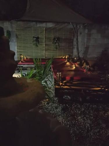 a person sitting in front of a street at night at Qué Chula casa. in Izamal