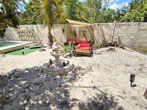 a backyard with a fire hydrant and a chair at Qué Chula casa. in Izamal