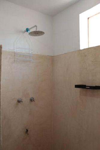 a bathroom with a shower with a shower head at Qué Chula casa. in Izamal