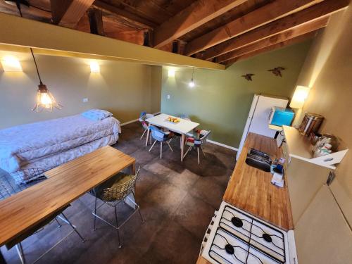 a room with a bed and a desk and a table at Maiten Apartamentos in San Carlos de Bariloche