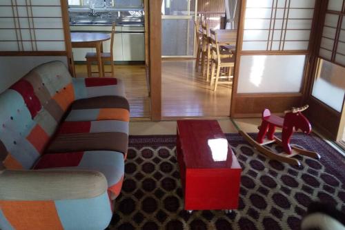 a living room with a couch and a dog toy at ちびっこ・わんこ・リゾート　Ｓａｒａｒｉ　（里楽里） in Tabuchi