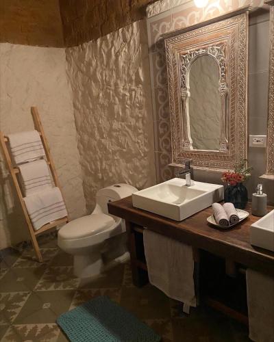 a bathroom with a sink and a toilet and a mirror at Casona Ananda in Firavitoba