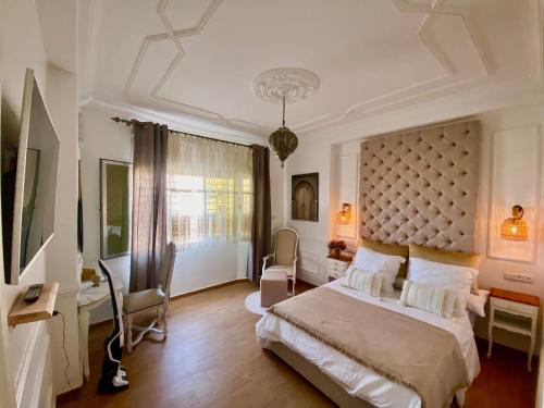 um quarto com uma cama grande e uma secretária em Appartement LOUIS XIV avec HAMMAM SAUNA JACCUZI PRIVATISÉ TOTALEMENT GRATUIT SANS SUPPLÉMENT ! em Al Hoceïma