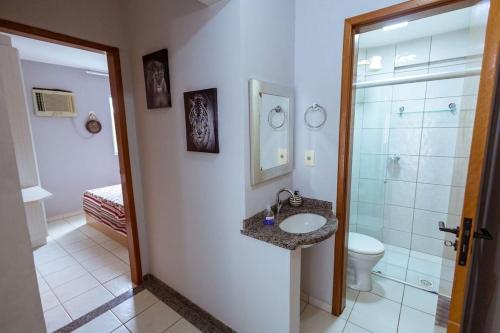 a bathroom with a sink and a toilet and a shower at Thermas Paradise - Rio Quente - Apto 2 quartos com Suíte in Rio Quente