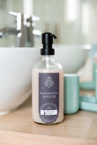 une bouteille de shampoing assise sur un comptoir dans l'établissement Maison de Larros, au calme idéalement placée, à Gujan-Mestras