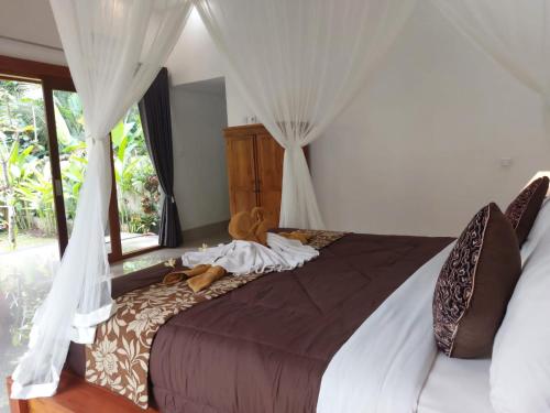 a bedroom with a large bed with curtains at Pondok Kukuh villa Sidemen in Sidemen