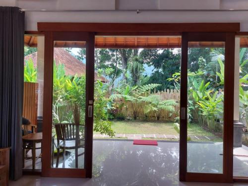 an open glass door with a view of a garden at Pondok Kukuh villa Sidemen in Sidemen