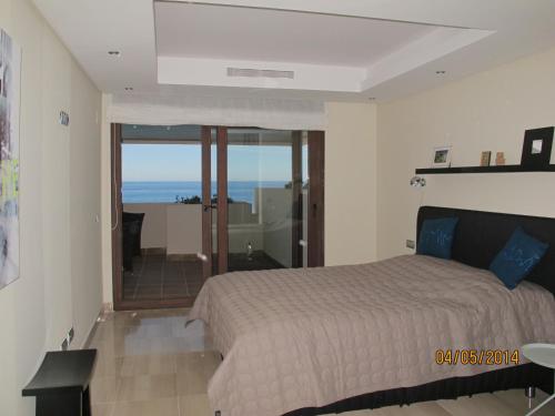 1 dormitorio con cama y vistas al océano en Bahia de la Plata, en Estepona