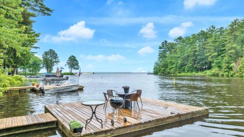a wooden dock with a table and chairs on the water at CRYSTAL OASIS- LIMIT 8 villa in North Sebago