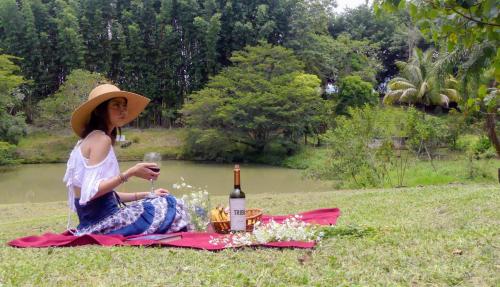 a woman sitting on a picnic blanket with a bottle of wine at Casa contenedor Finca la laguna in Córdoba