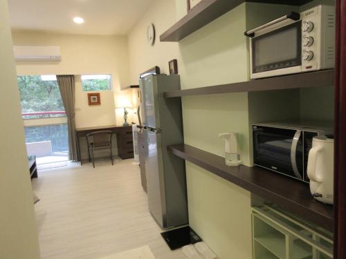 um quarto com uma cozinha com um micro-ondas e um frigorífico em 知本溫泉家 em Hua-yüan