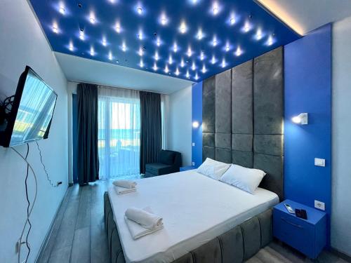 a bedroom with a large bed with a blue wall at Aurora apartments on the beach in Obzor