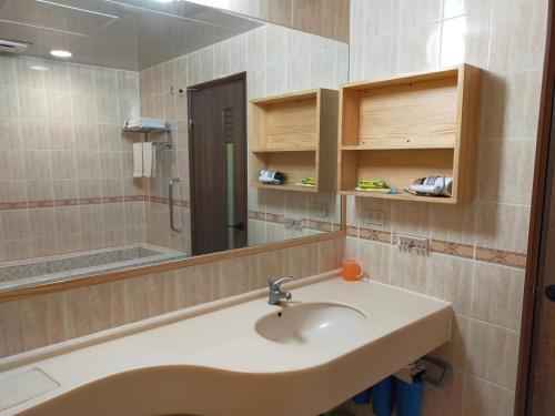 La salle de bains est pourvue d'un lavabo et d'un miroir. dans l'établissement 知本溫泉家, à Hua-yüan