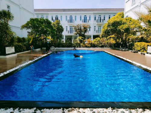 a person swimming in a large blue swimming pool at Aroma home in Da Nang