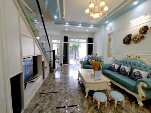 a living room with a blue couch and a tv at Aroma home in Da Nang
