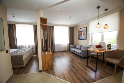 ein Wohnzimmer mit einem Bett, einem Sofa und einem Tisch in der Unterkunft Chagala Residence Atyrau in Atyrau
