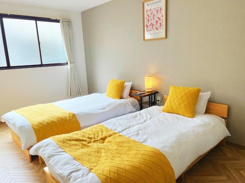 大阪市にあるSummit Villa 100sqm Osaka Nakazakicho Stationのベッド2台が隣同士に設置された部屋です。
