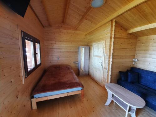 um quarto num chalé de madeira com uma cama e um banco em DOMKIwJASTRZEBIEJ em Jastrzebia Gora