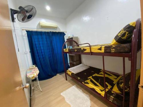 a room with two bunk beds and a blue curtain at Lisa Homestay Sandakan in Sandakan