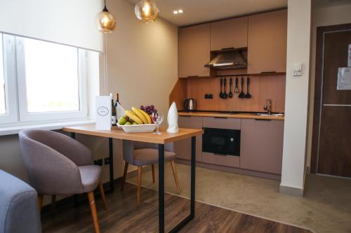 a kitchen with a table with a bowl of fruit on it at Chagala Residence Atyrau in Atyraū