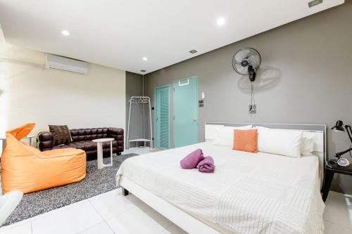a bedroom with a large white bed and a couch at CB's - Cheap Boutique Bangkok in Bangkok