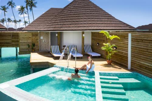 two people in a swimming pool in a villa at Sun Siyam Olhuveli in South Male Atoll