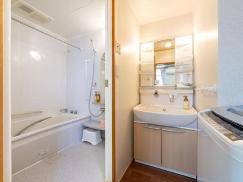 ein Badezimmer mit einem Waschbecken, einer Badewanne und einem WC in der Unterkunft Travel Inn Kofu in Kofu