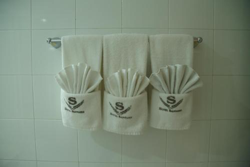 three white towels on a rack in a bathroom at Hotel Sapphire in Colombo