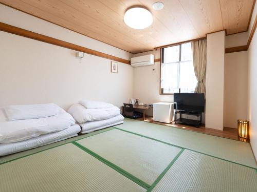 um quarto com 2 camas e uma televisão de ecrã plano em Travel Inn Kofu em Kofu