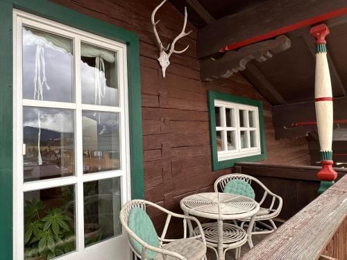 a porch with a table and chairs and a window at Obinghof in Fieberbrunn