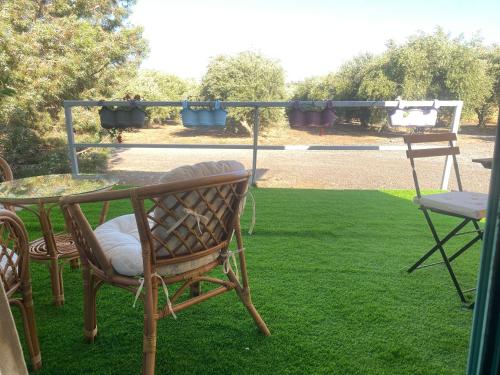 eine Terrasse mit einem Tisch und Stühlen auf dem Rasen in der Unterkunft heart of the golan heights cabin -בקתה במטע in Eli Ad