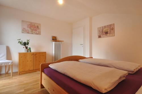 a bedroom with a bed and a chair in it at Melaniesguesthouse 4 Zimmerwohnung in Caldaro