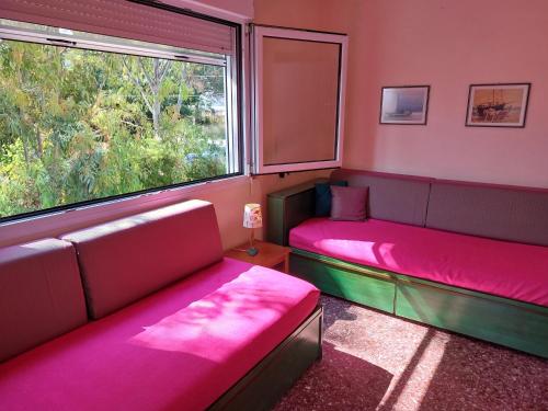 een kamer met 2 bedden en een raam bij ALKIONIS , Apartment by the sea in Halkidiki in Pefkochori