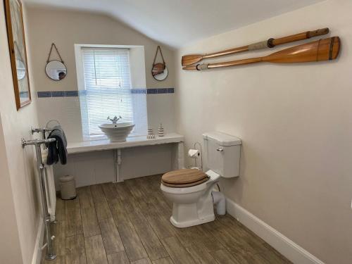 a bathroom with a toilet and a sink and a window at Netherraw in Newcastleton