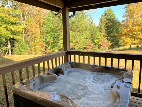 a hot tub on a deck with a view of trees at A Dream Come True cabin in Sevierville