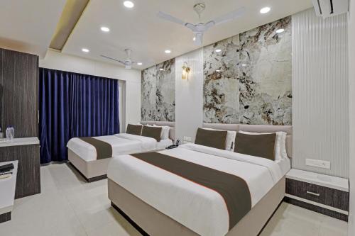 Habitación de hotel con 2 camas y baño en Super Collection O Hotel Alpha One, en Ahmedabad