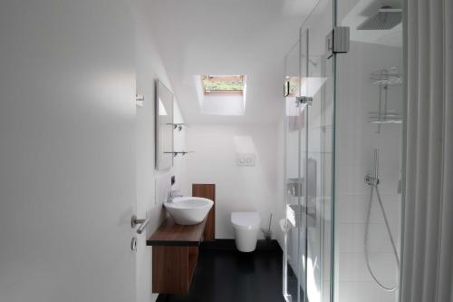 a white bathroom with a sink and a shower at Melaniesguesthouse 4 Zimmerwohnung in Caldaro