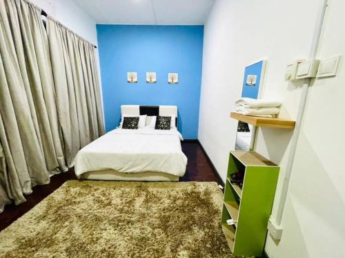 1 dormitorio con cama y pared azul en Double Storey terrace house in Sandakan Sabah, en Sandakan