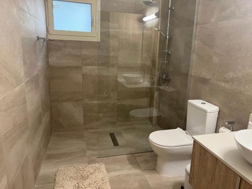 a bathroom with a shower and a toilet and a sink at Walnut Cozy House in Goudhi
