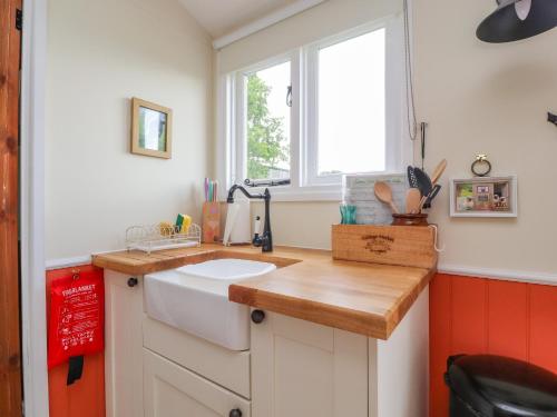 a small kitchen with a sink and a window at The Journeyman Luxury Shepherds Hut in Barnoldswick