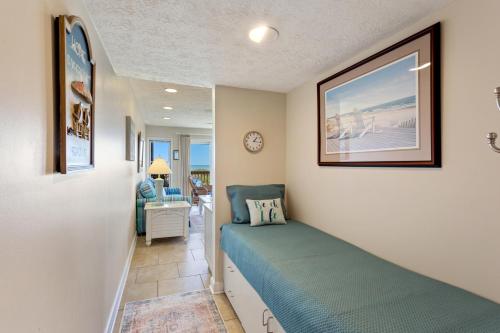 a bedroom with a bed in a room with the ocean at Oceanfront Shared Pool C102A Sea over the Dune in Duck