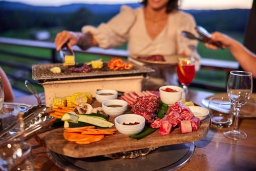 a woman is preparing food on a table at KUR-Cow farm escape 35 minutes from Cairns in Kuranda