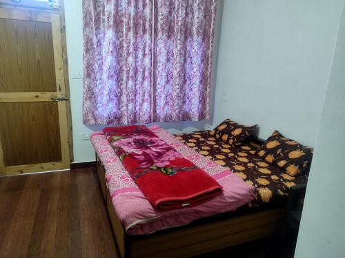 a bed in a room with a purple window at Pranjal home stay in Polang