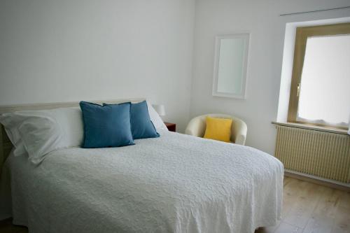 a bedroom with a bed with blue pillows and a window at B&B The Secret Garden in Buia
