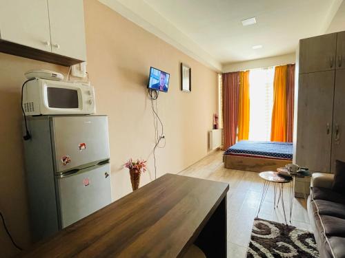 a small living room with a refrigerator and a bed at Natia rooms in Tbilisi City
