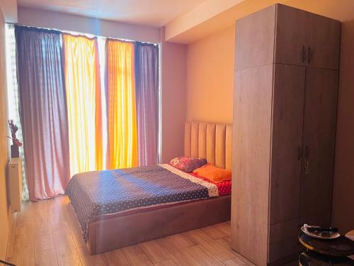 a small bed in a room with a large window at Natia rooms in Tbilisi City