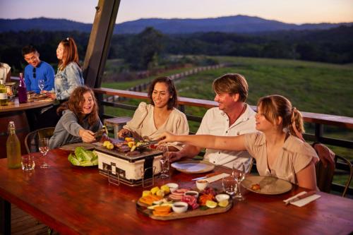 a group of people sitting at a table with food at KUR-Cow farm escape 35 minutes from Cairns in Kuranda