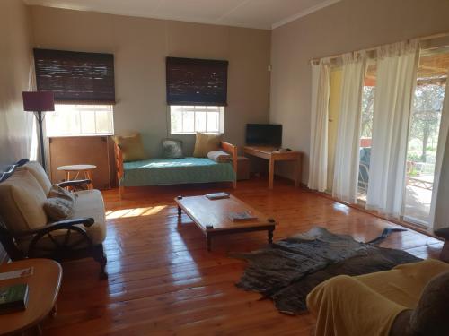 a living room with a couch and a table at Scheepers Rust Guest Farmhouse in Montagu