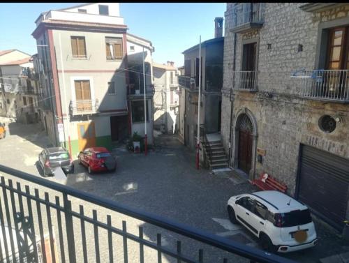 a balcony with a white car parked on a street at Delizioso appartamento al centro di Bosco SAN GIOVANNI A PIRO in Casal Sottano