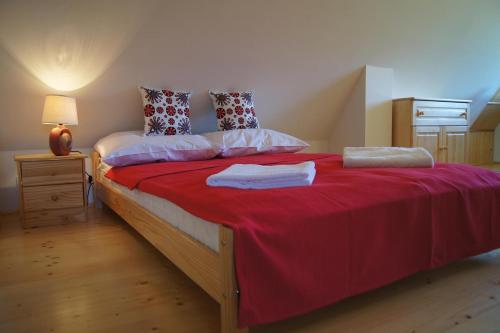 a bedroom with a large bed with a red blanket at Apartament Mountain View in Kościelisko